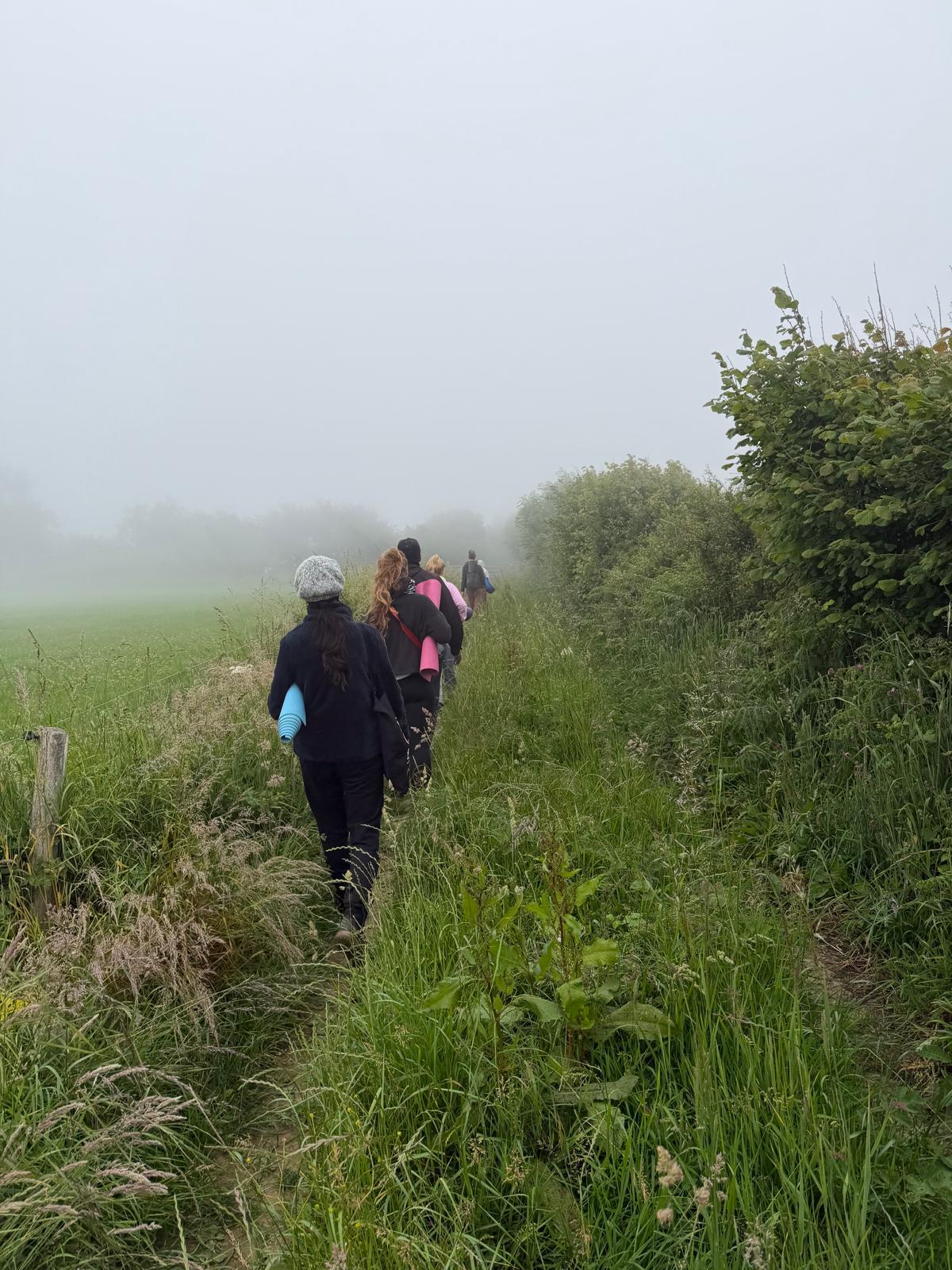 Walking out through a misty field together, mats under their arms